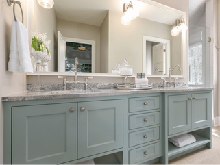 Green-gray cabinets of vanity with one big mirror and two sinks