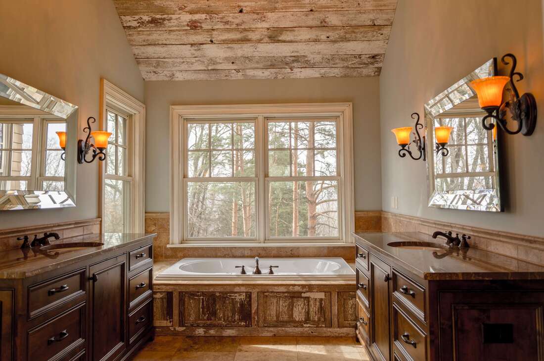 Wood-style bathroom with big bathtub and two single, separate vanities